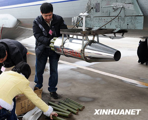 資料圖:2月8日,在河南省鄭州市新鄭機(jī)場(chǎng),工作人員往飛機(jī)上裝掛人工增雨用的碘化銀催化劑。