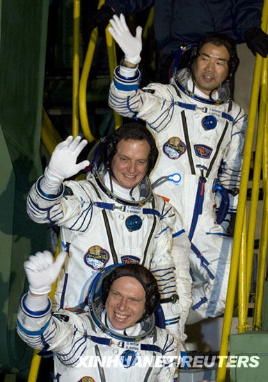 21日，在哈薩克斯坦境內的拜科努爾航天發射中心，國際空間站第22長期考察組成員俄羅斯宇航員奧列格·科托夫、美國宇航員蒂莫西·克里默和日本宇航員野口聰一（從下至上）在進入飛船前向人們揮手。