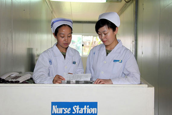 圖為護(hù)士長高翠玲(左)和護(hù)士孫艷傳授護(hù)理技巧。